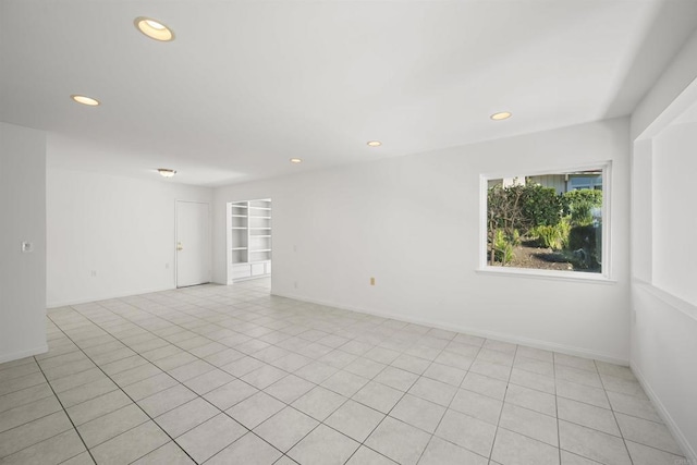 unfurnished room featuring built in features and light tile patterned flooring