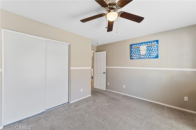 unfurnished bedroom with ceiling fan, a closet, and light colored carpet