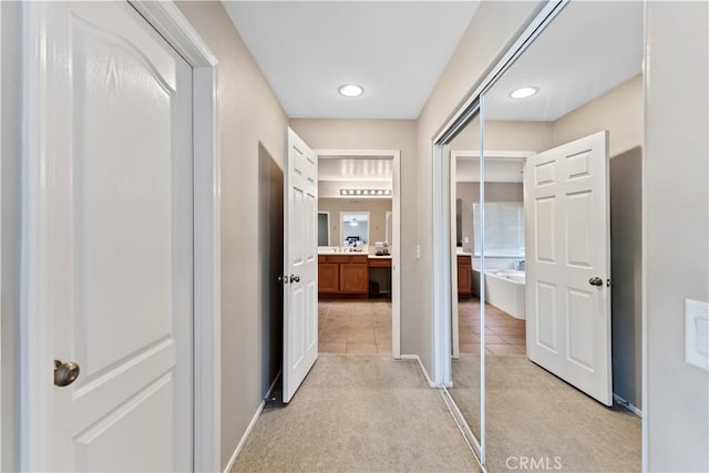 hall with light colored carpet