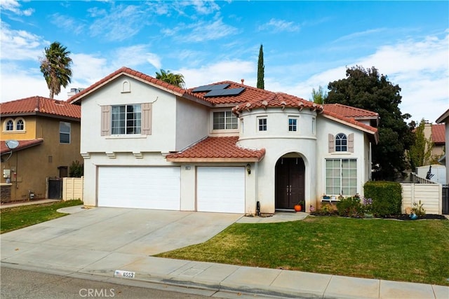 mediterranean / spanish home featuring solar panels, a front lawn, and a garage