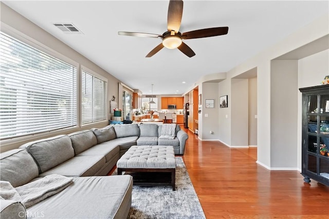 living room with ceiling fan and light wood-type flooring