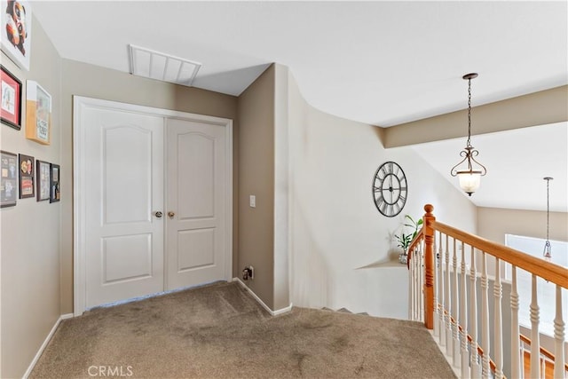 corridor with carpet flooring and vaulted ceiling