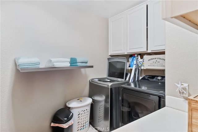 laundry room featuring cabinets and washing machine and dryer