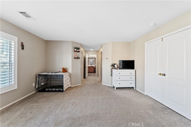 unfurnished bedroom with light colored carpet and a closet