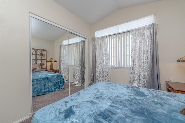 carpeted bedroom with a closet and lofted ceiling