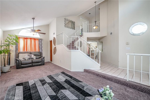 carpeted living room featuring ceiling fan and high vaulted ceiling