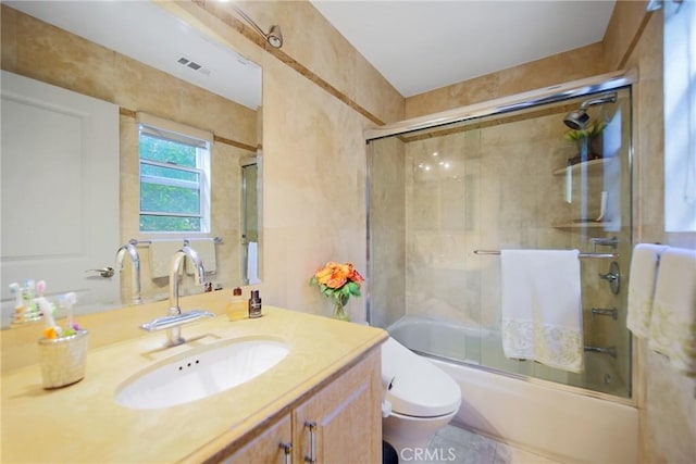 full bathroom featuring toilet, vanity, and combined bath / shower with glass door