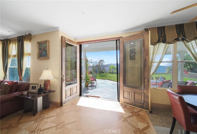 entryway featuring ceiling fan and ornamental molding