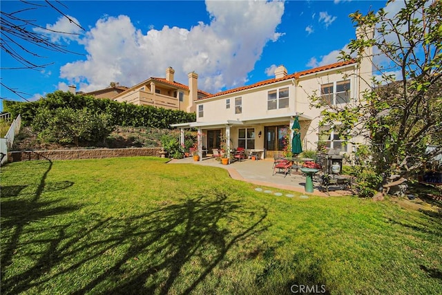 rear view of house featuring a patio area and a yard