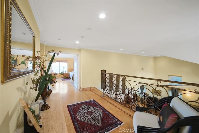 hall with light hardwood / wood-style flooring and ornamental molding