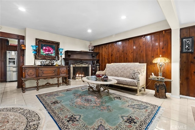 living area with light tile patterned flooring and wood walls