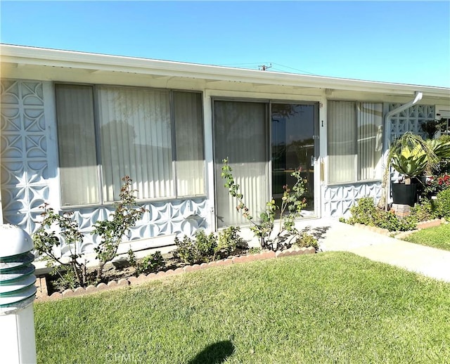 view of exterior entry with a yard