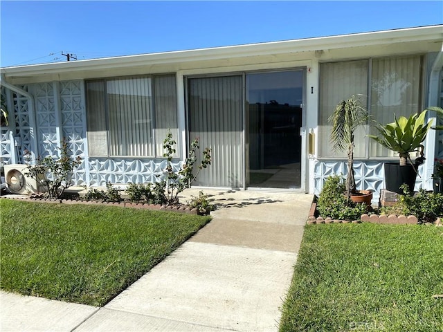 property entrance featuring a lawn