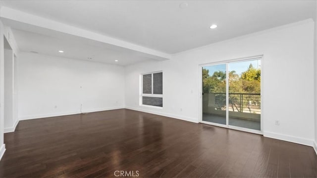 spare room with beamed ceiling and dark wood-type flooring