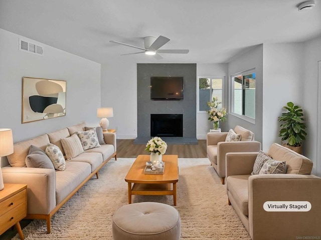 living room featuring a fireplace, ceiling fan, and hardwood / wood-style flooring