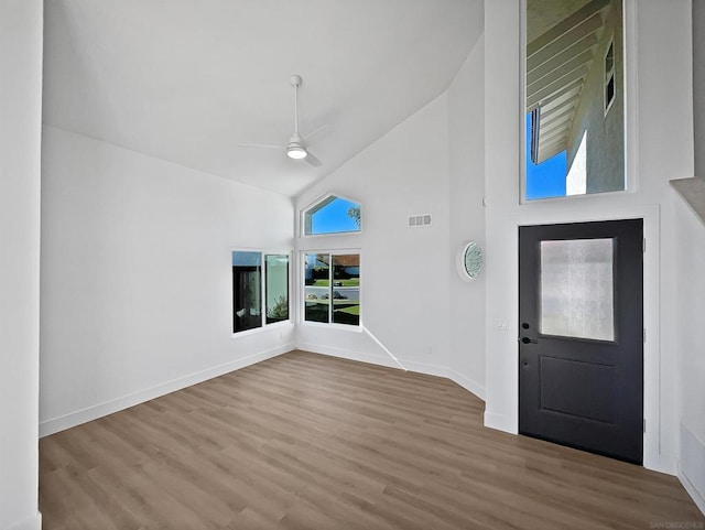 foyer entrance with hardwood / wood-style flooring, high vaulted ceiling, and ceiling fan