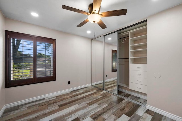 unfurnished bedroom featuring ceiling fan, a closet, and wood-type flooring