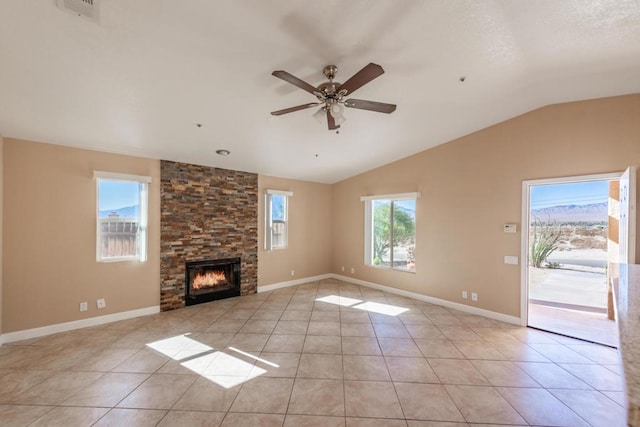 unfurnished living room with ceiling fan, light tile patterned floors, lofted ceiling, and a stone fireplace