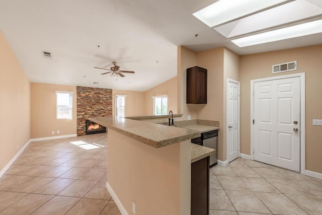 kitchen featuring dishwasher, lofted ceiling, light tile patterned flooring, ceiling fan, and dark brown cabinets