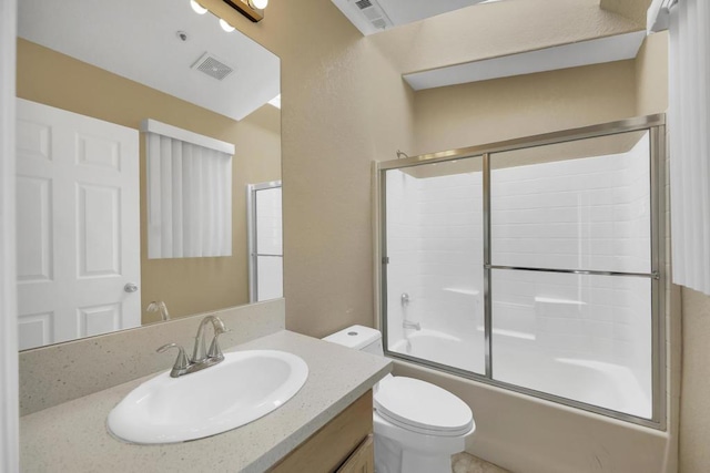 full bathroom with combined bath / shower with glass door, vanity, and toilet