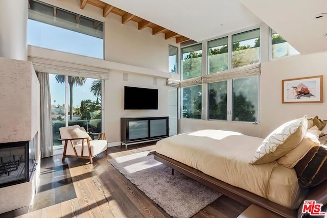 bedroom featuring a multi sided fireplace and multiple windows