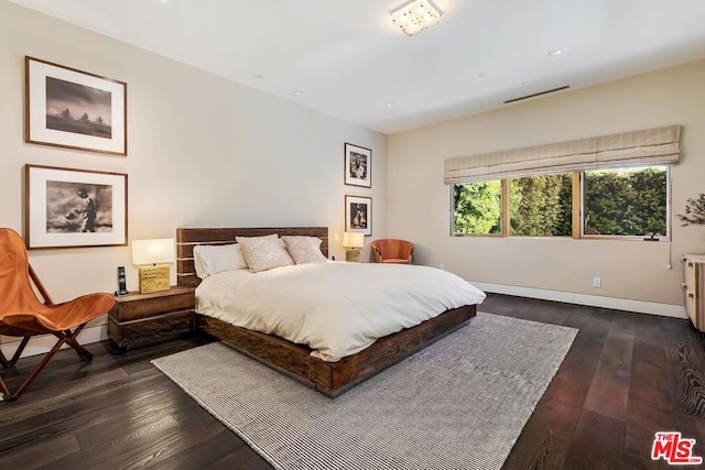 bedroom with dark hardwood / wood-style flooring