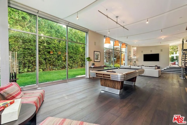 recreation room featuring plenty of natural light, dark hardwood / wood-style flooring, a wall of windows, and billiards