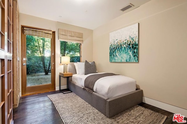 bedroom with access to exterior and dark hardwood / wood-style floors