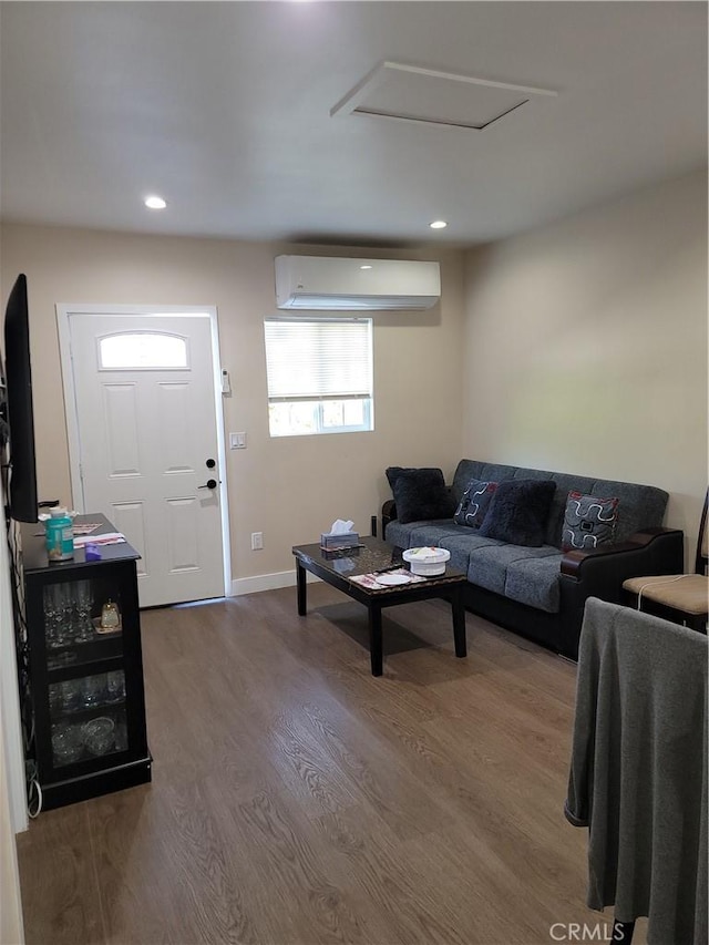 living room featuring hardwood / wood-style floors and an AC wall unit