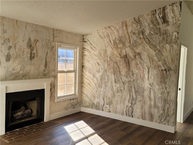 unfurnished living room featuring dark hardwood / wood-style flooring and a textured ceiling