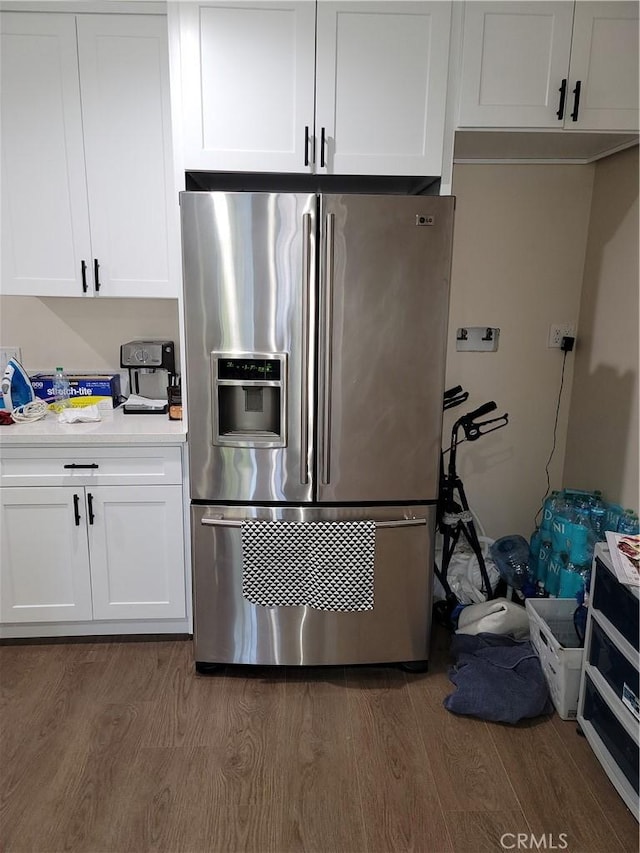 kitchen featuring white cabinetry, stainless steel fridge, and dark hardwood / wood-style flooring