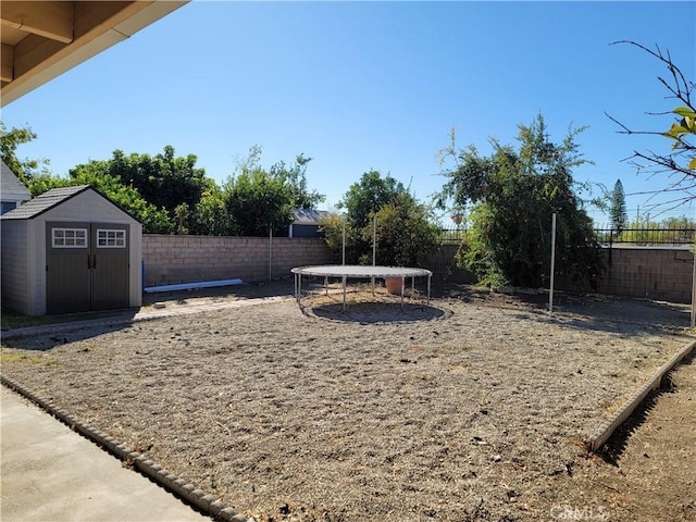 view of yard with a storage shed and a trampoline