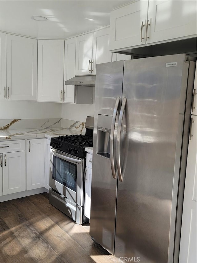 kitchen with light stone countertops, white cabinetry, stainless steel appliances, and dark wood-type flooring