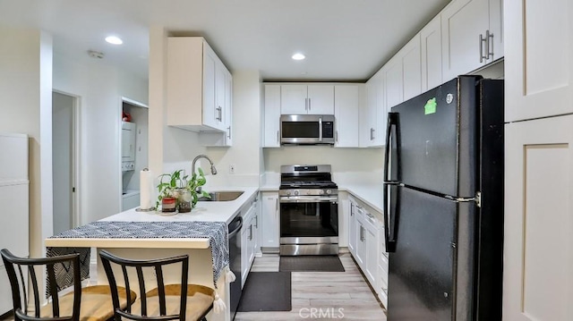 kitchen featuring light hardwood / wood-style floors, sink, white cabinetry, and stainless steel appliances