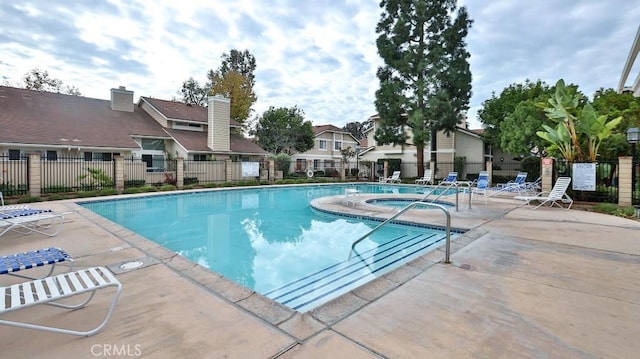 view of pool with a patio and a hot tub