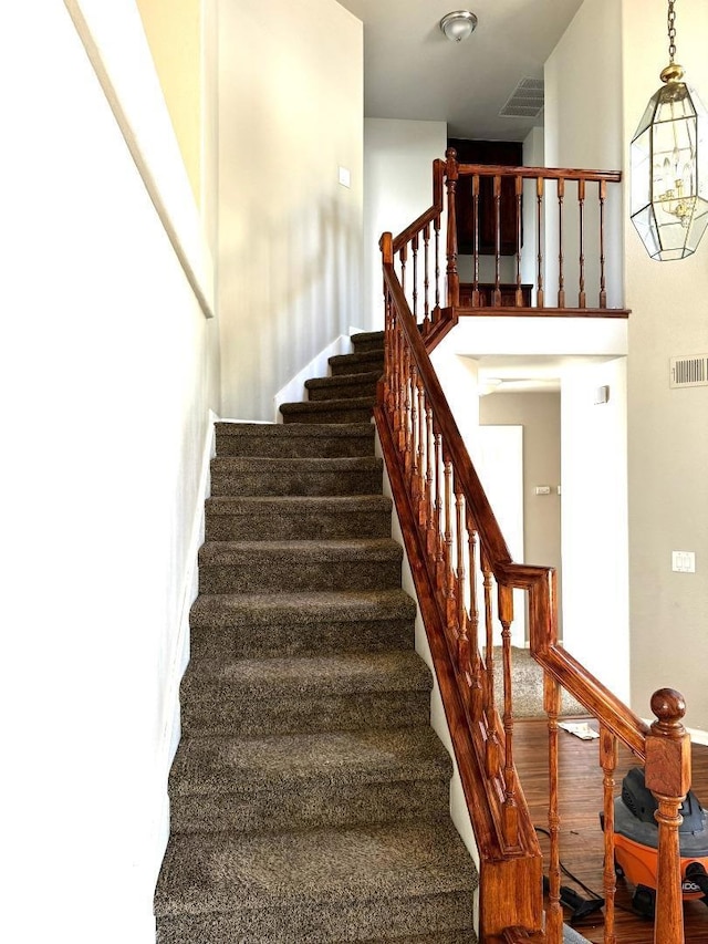 stairs with a chandelier