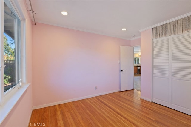 unfurnished bedroom with a closet, light hardwood / wood-style floors, and ornamental molding