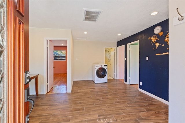 clothes washing area featuring hardwood / wood-style flooring and washer / dryer