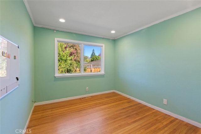 unfurnished room featuring light hardwood / wood-style flooring and crown molding