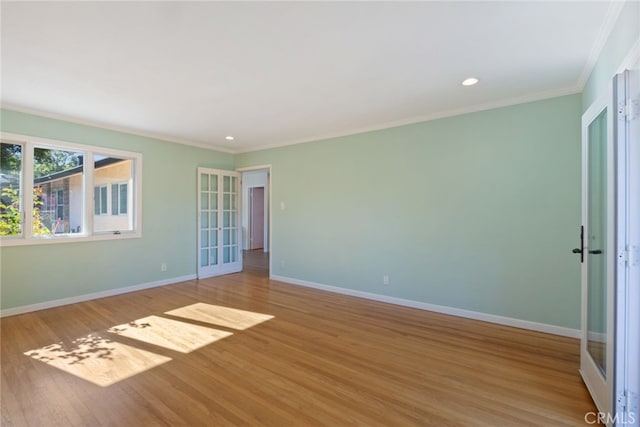 spare room featuring crown molding, french doors, and light wood-type flooring