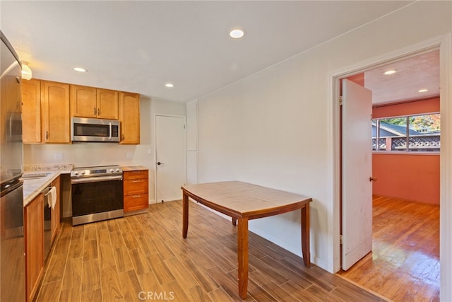 kitchen with stainless steel appliances and light hardwood / wood-style floors