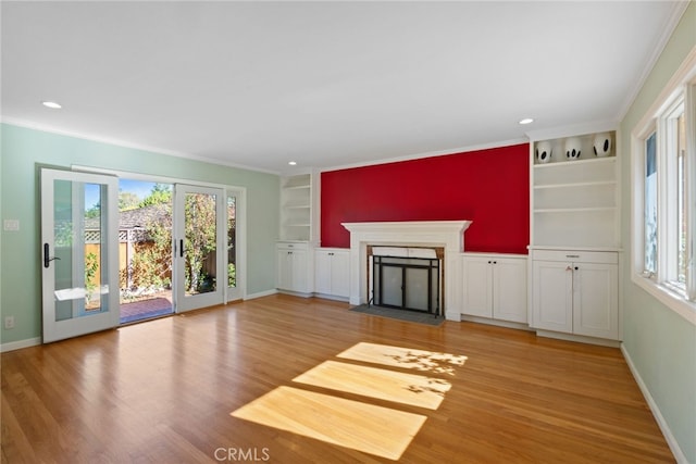 unfurnished living room with built in shelves, french doors, wood-type flooring, and ornamental molding