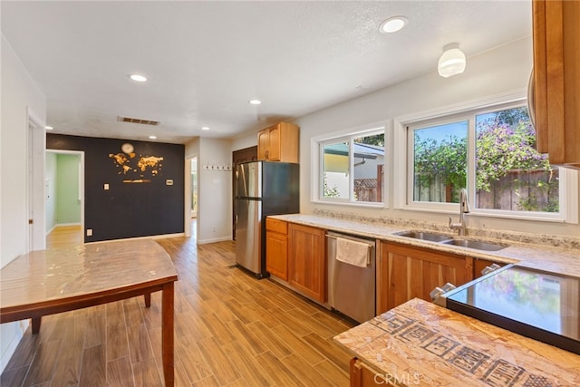 kitchen with sink, light wood-type flooring, and appliances with stainless steel finishes