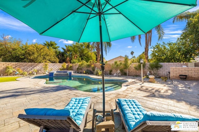 view of pool with a patio area and an in ground hot tub