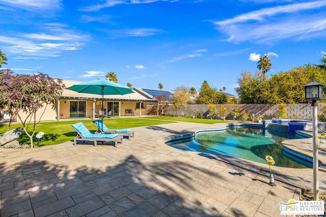 view of swimming pool with a patio area, a yard, and an in ground hot tub