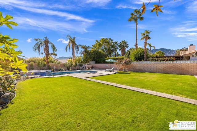 view of yard featuring a mountain view, a swimming pool with hot tub, and central air condition unit