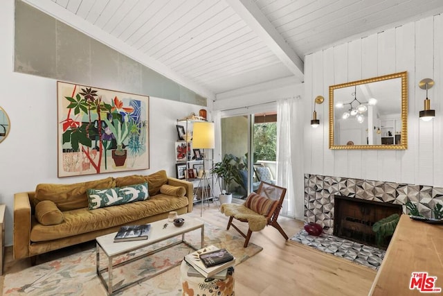 living room featuring wooden ceiling, an inviting chandelier, lofted ceiling with beams, a fireplace, and wood-type flooring