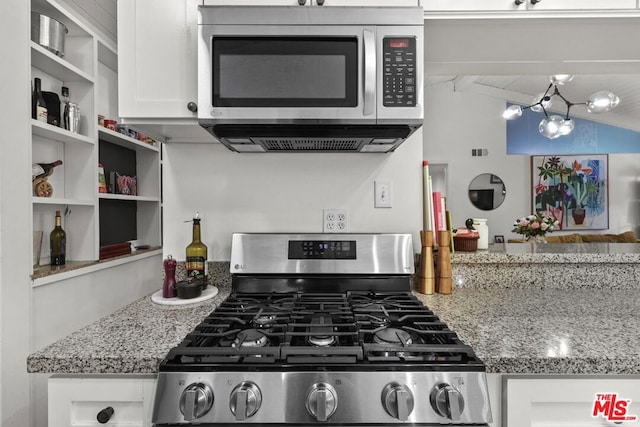 kitchen with light stone counters, white cabinets, lofted ceiling with beams, and range