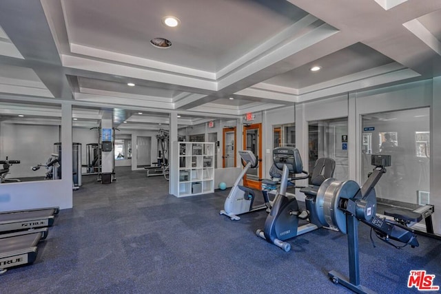 exercise room featuring a raised ceiling and french doors