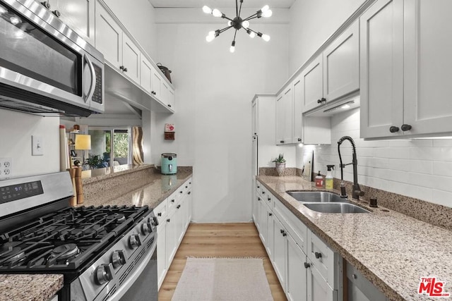 kitchen with light stone countertops, white cabinets, and appliances with stainless steel finishes